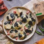 Ravioli recheado de Queijo de Castanha de Caju com Cranberry. Raviolis servidos em um prato.