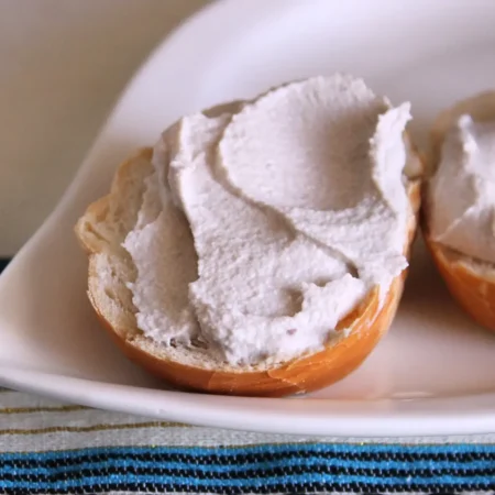 Queijo Cremoso de Castanha de Caju com Azeitona Preta espalhado sobre um pedaço de pão.