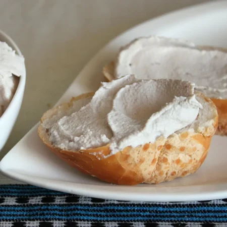 Queijo Cremoso de Castanha de Caju Culinário espalhado sobre um pedaço de pão.