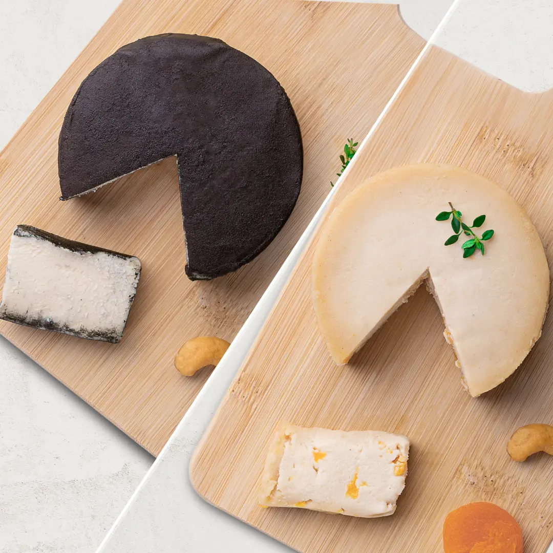 O kit contém 2 Queijos de Castanha de Caju: 1 Queijo de Castanha de Caju Defumado e 1 Queijo de Castanha de Caju Trufado com Damasco. Os queijos são fotografados de cima.